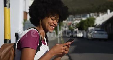 人行道上智能手机上的混血女人